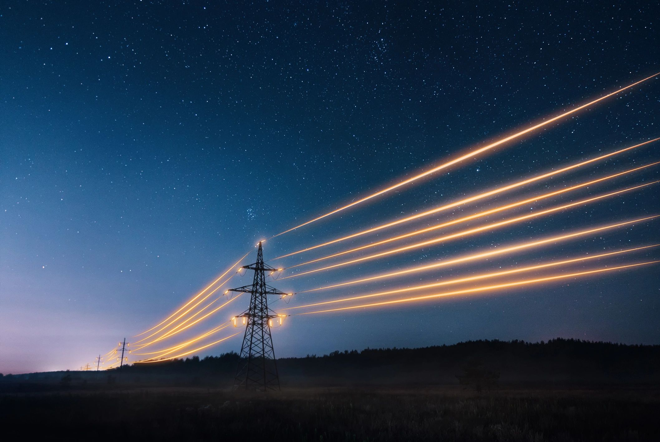 Power lines glowing with bright streaks under a starry night sky.